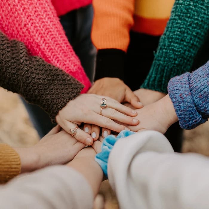 Groupe de personnes faisant preuve d'unité mettant les mains les unes sur les autres