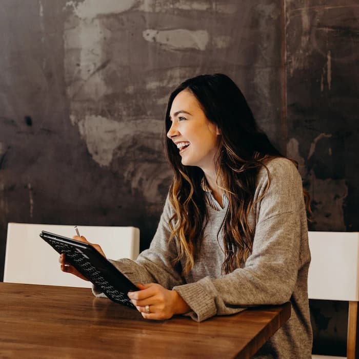 Femme souriante avec une tablette dans ses mains