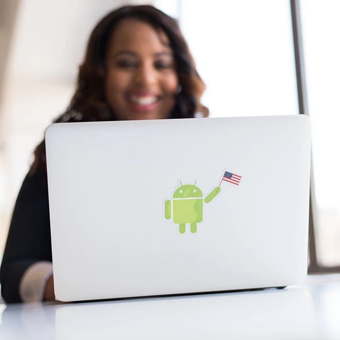 Une femme souriante qui regarde son ordinateur