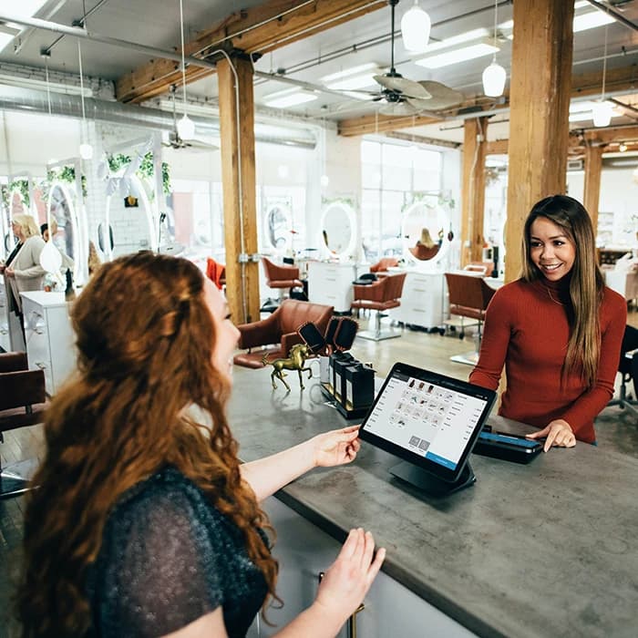 Une femme qui passe commande sur une borne digitale en magasin